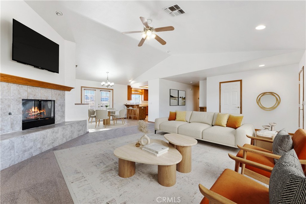 a living room with furniture kitchen view and a flat screen tv