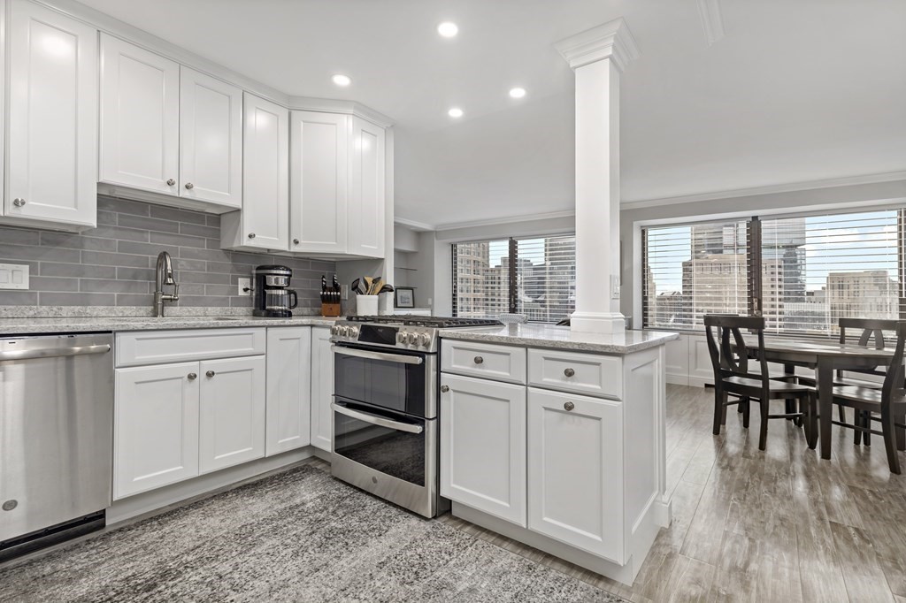 a kitchen with white cabinets appliances and a dining table