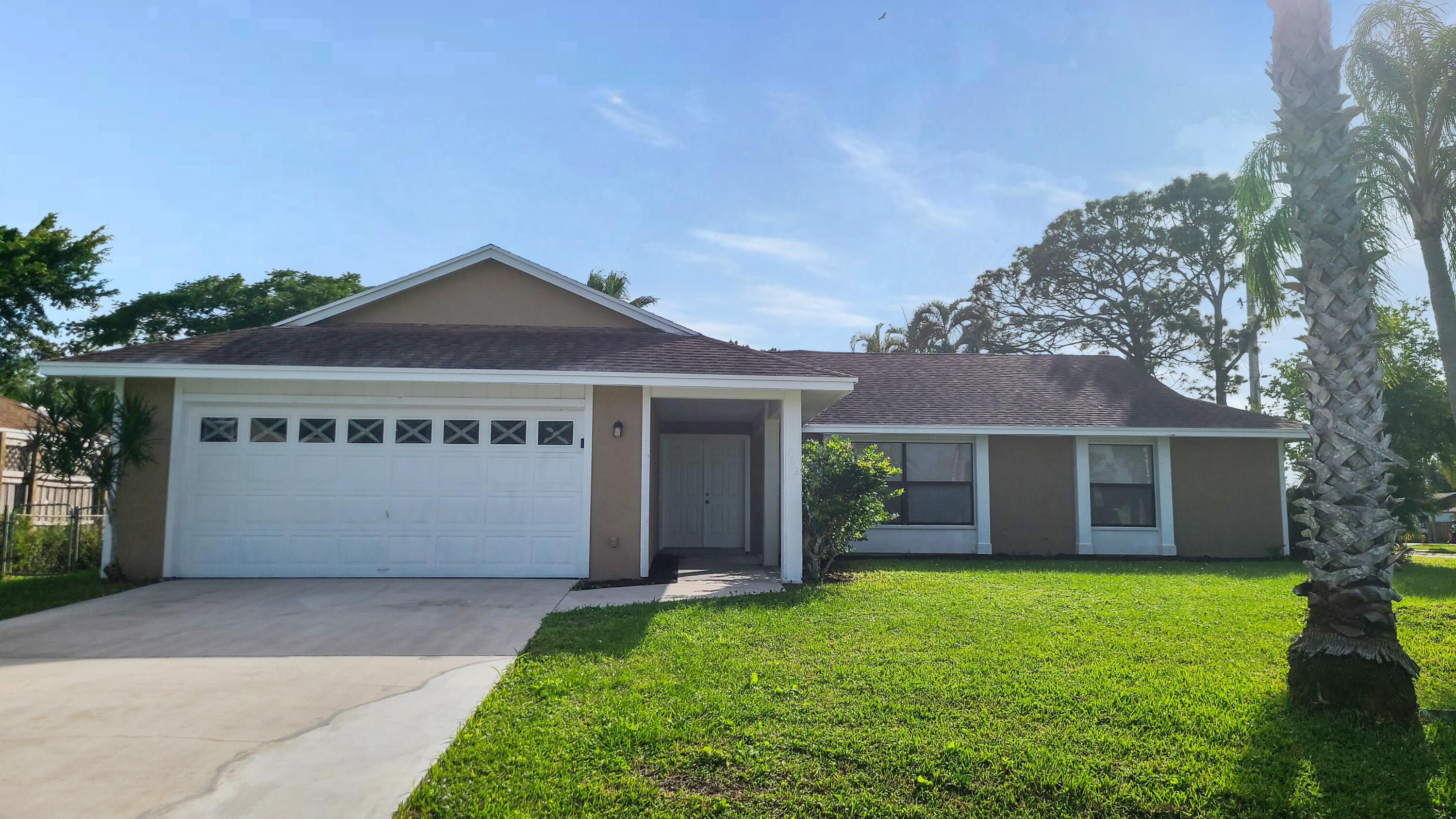 a front view of a house with a garden and yard