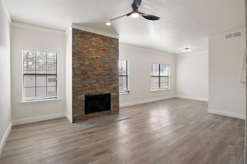 an empty room with windows and fireplace