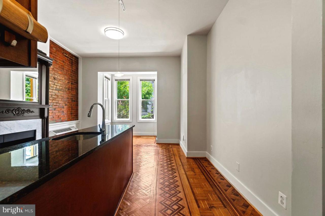 a view of a large kitchen with wooden floor and a window