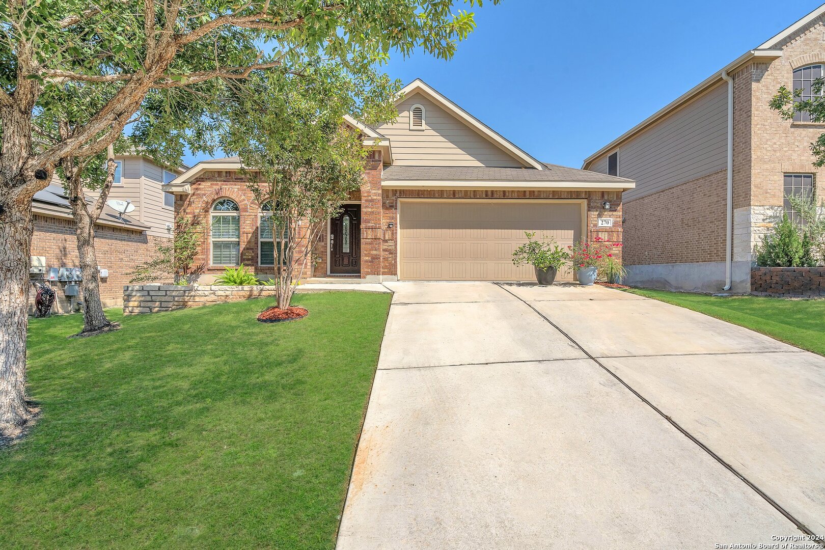 a front view of a house with a yard and trees