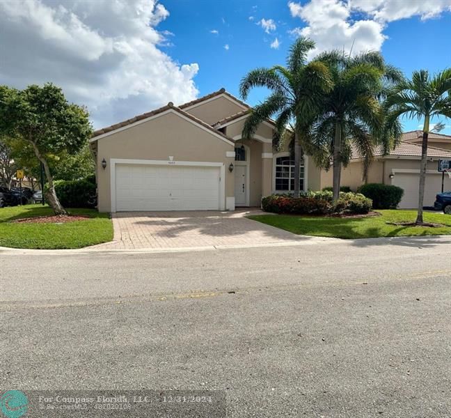 a view of a house with a yard and palm trees