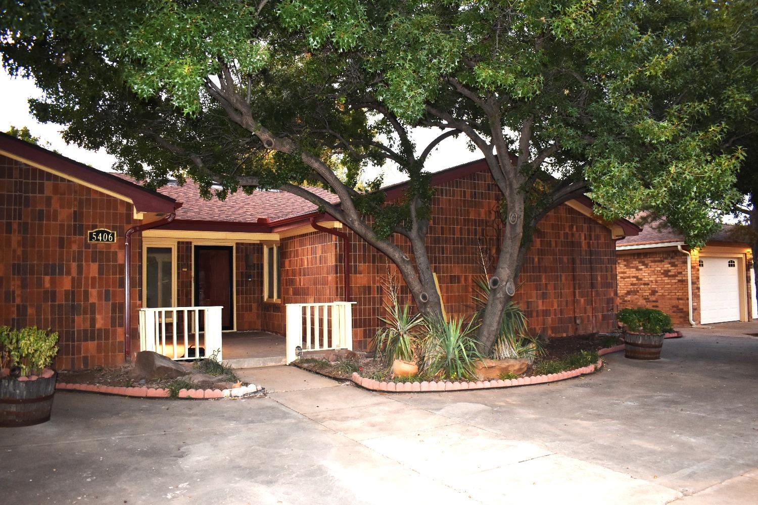 a view of a house with a tree in front