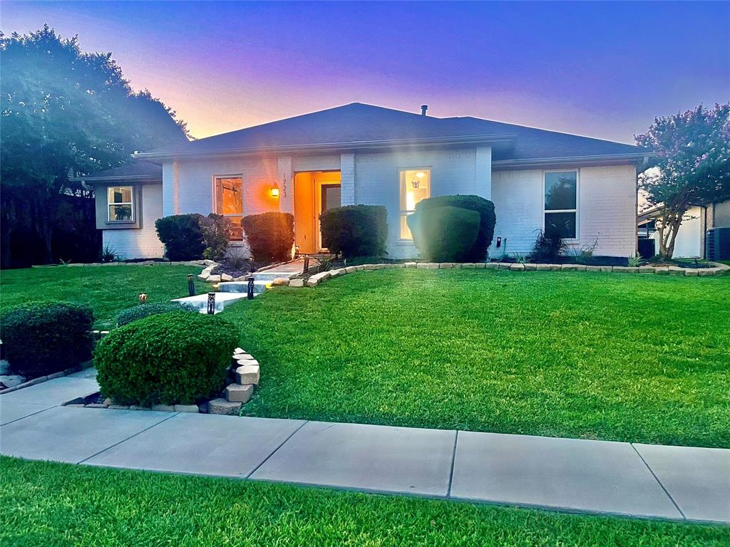 front view of a house with a yard and a garden