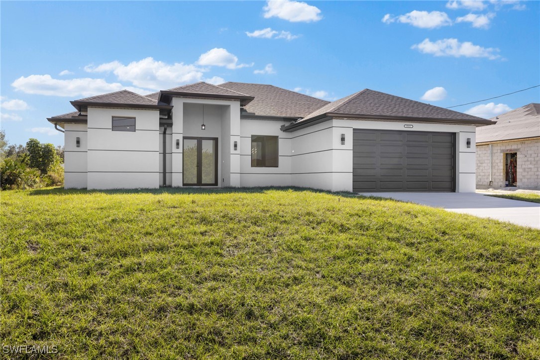 a front view of a house with yard and garage