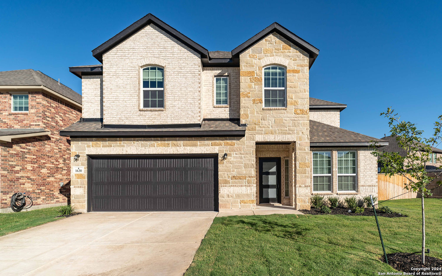 a front view of a house with a yard and garage