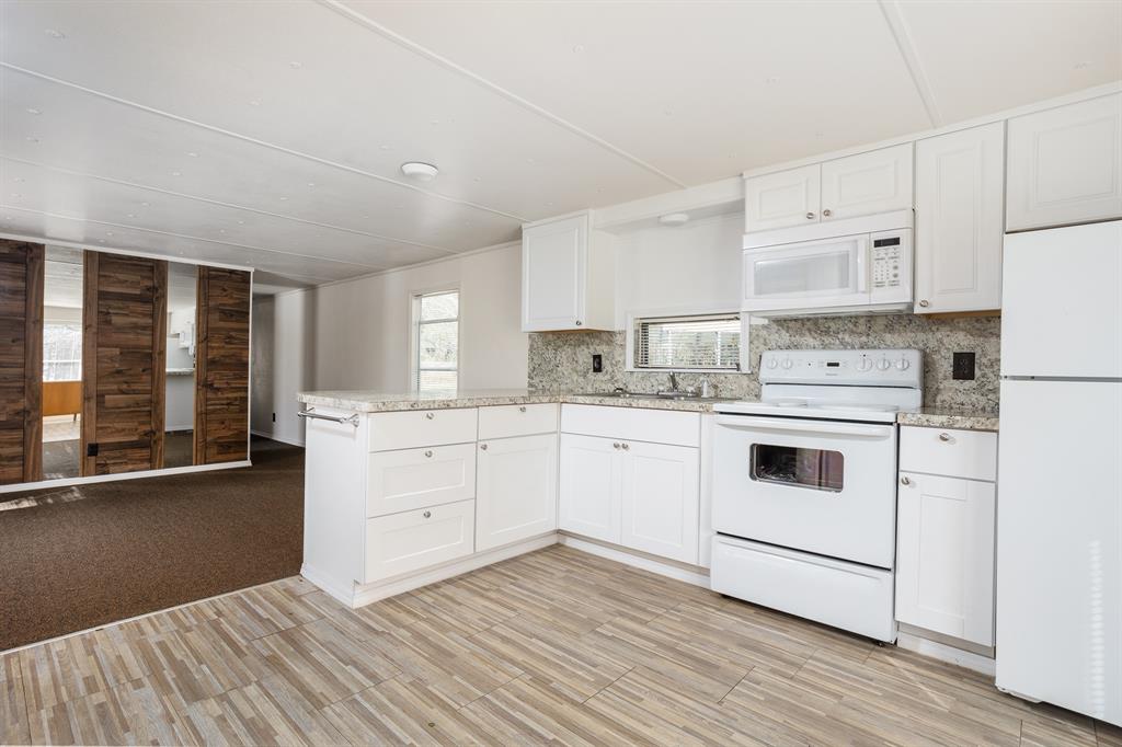 a kitchen with white cabinets and white appliances