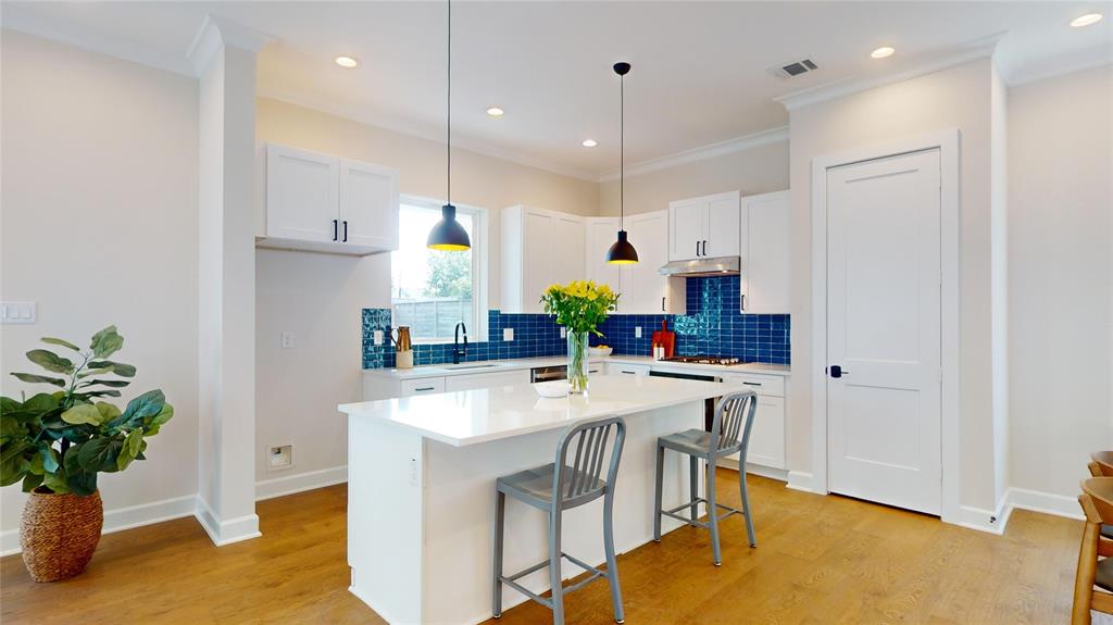 a kitchen with kitchen island a stove a table and chairs in it