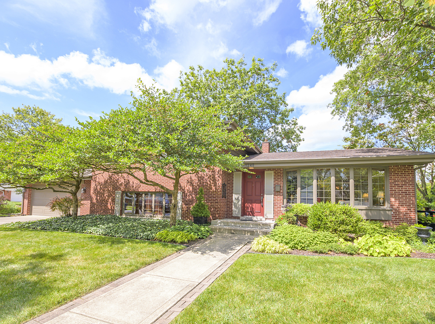 a front view of house with yard and green space