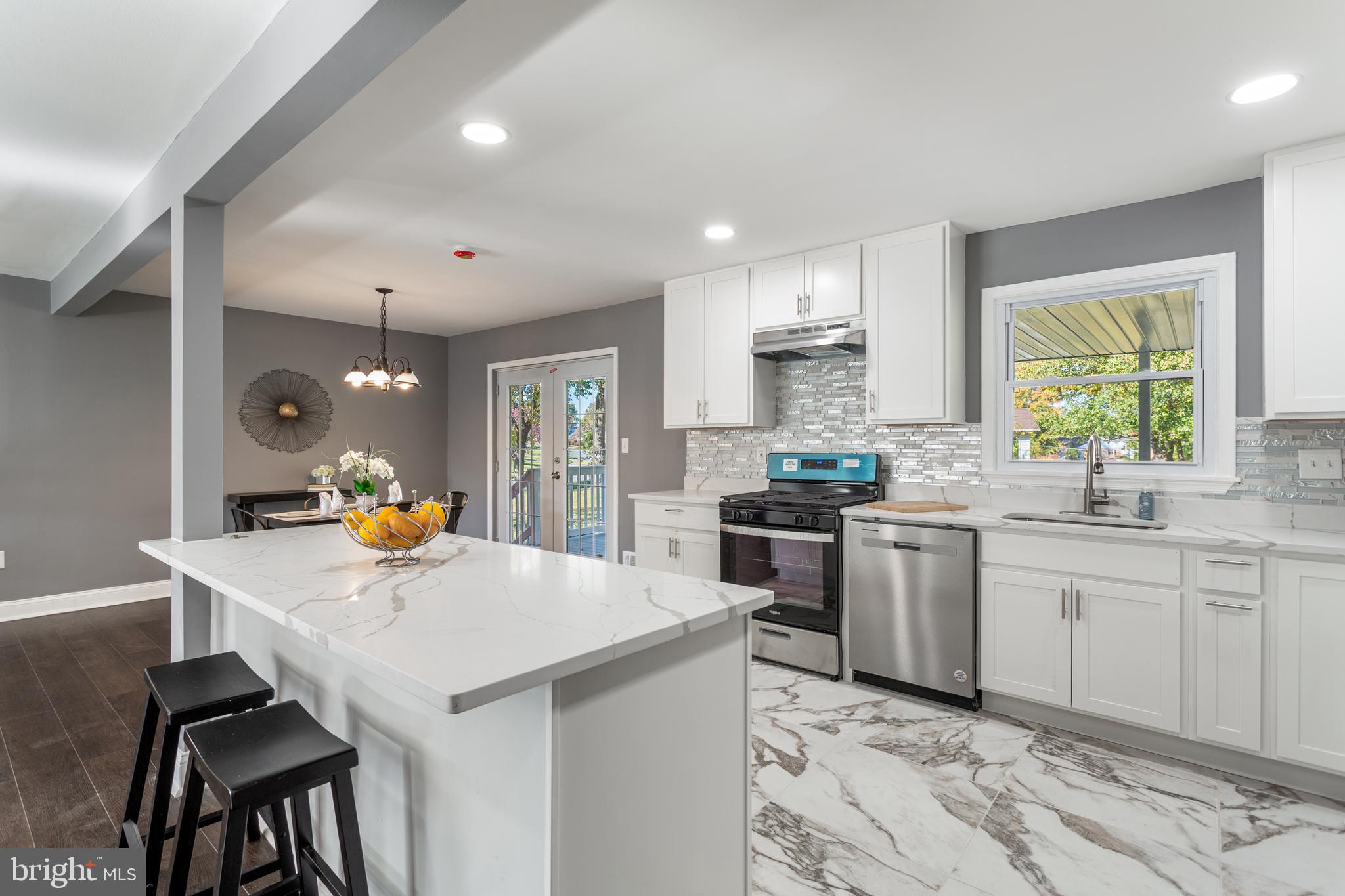 a kitchen with granite countertop a sink stove and refrigerator