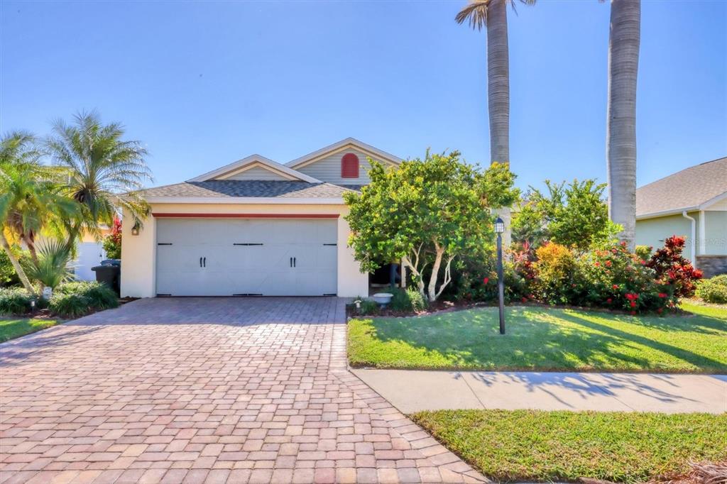 a house with a yard plants and large tree