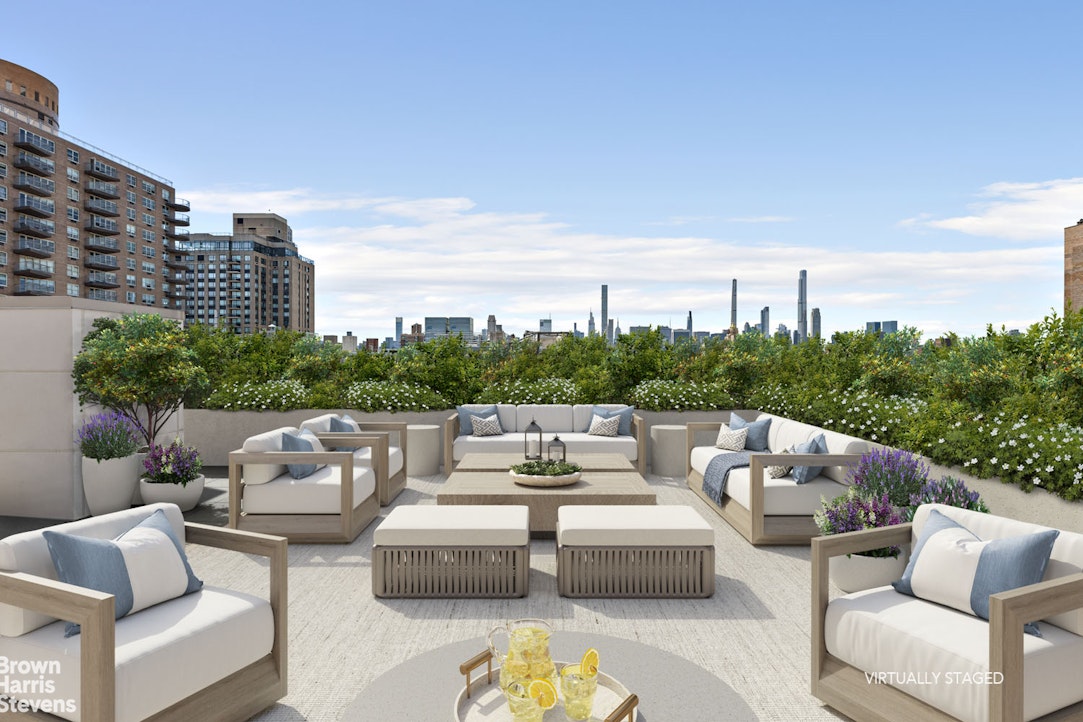 a view of a roof deck with couches and potted plants