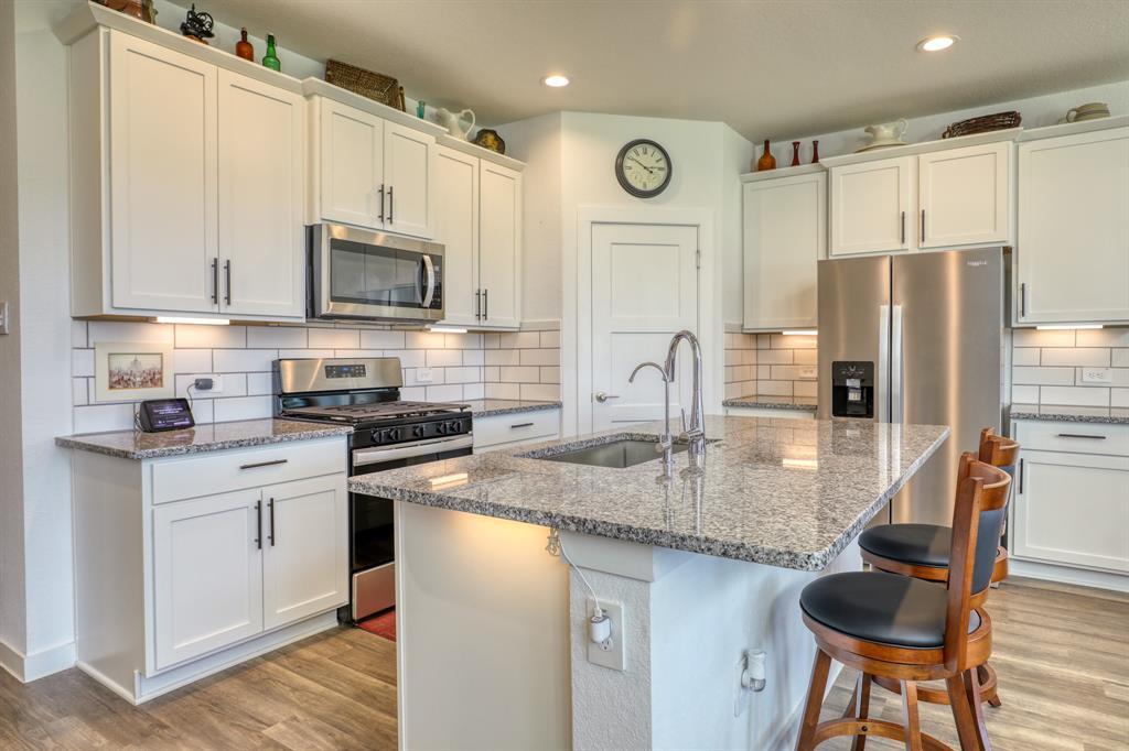 a kitchen with stainless steel appliances granite countertop a stove refrigerator sink and cabinets