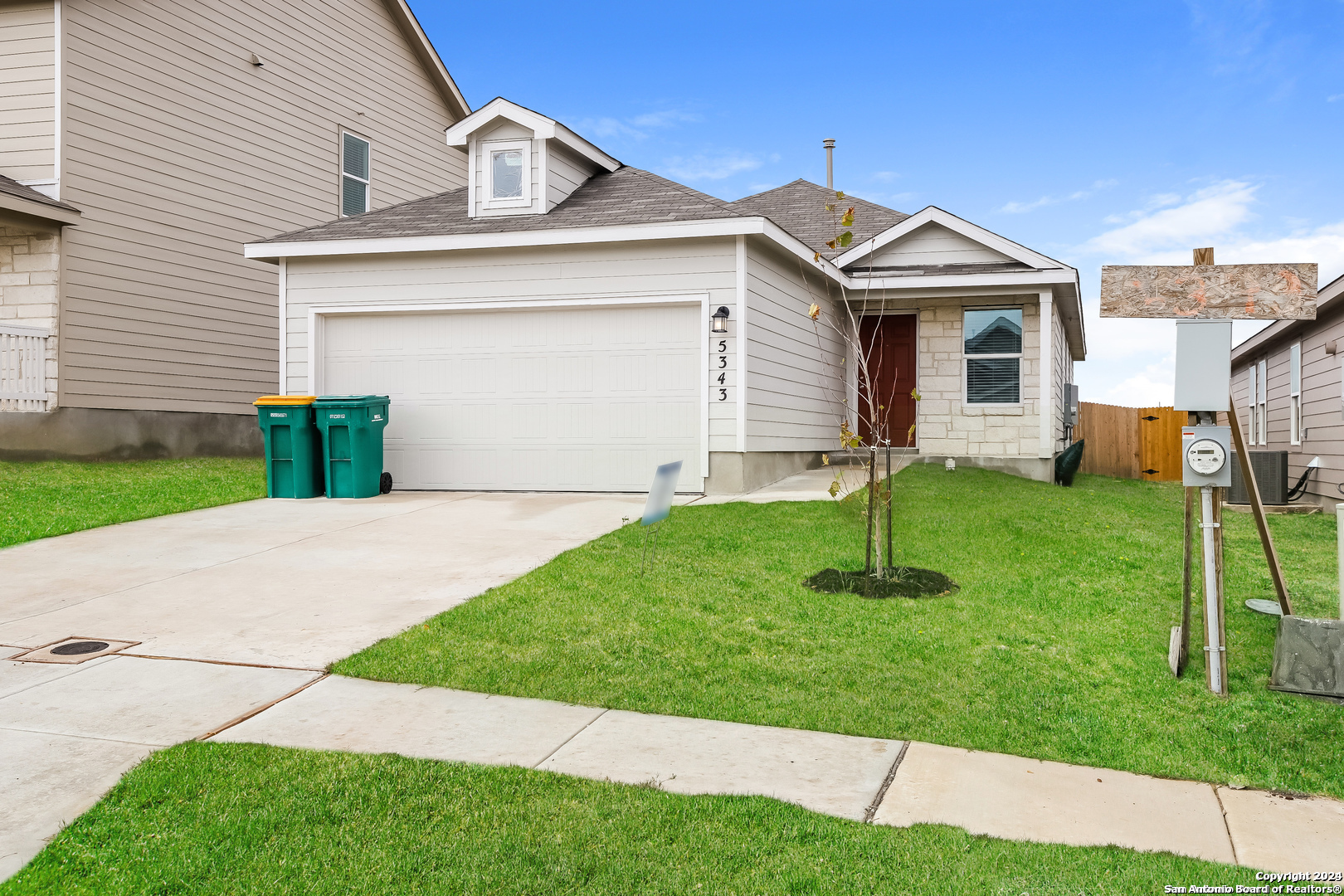 a front view of a house with a yard and trees