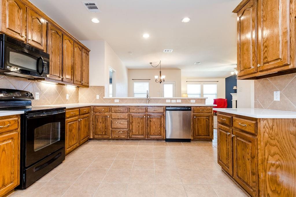 a kitchen with stainless steel appliances granite countertop a stove a sink and a microwave