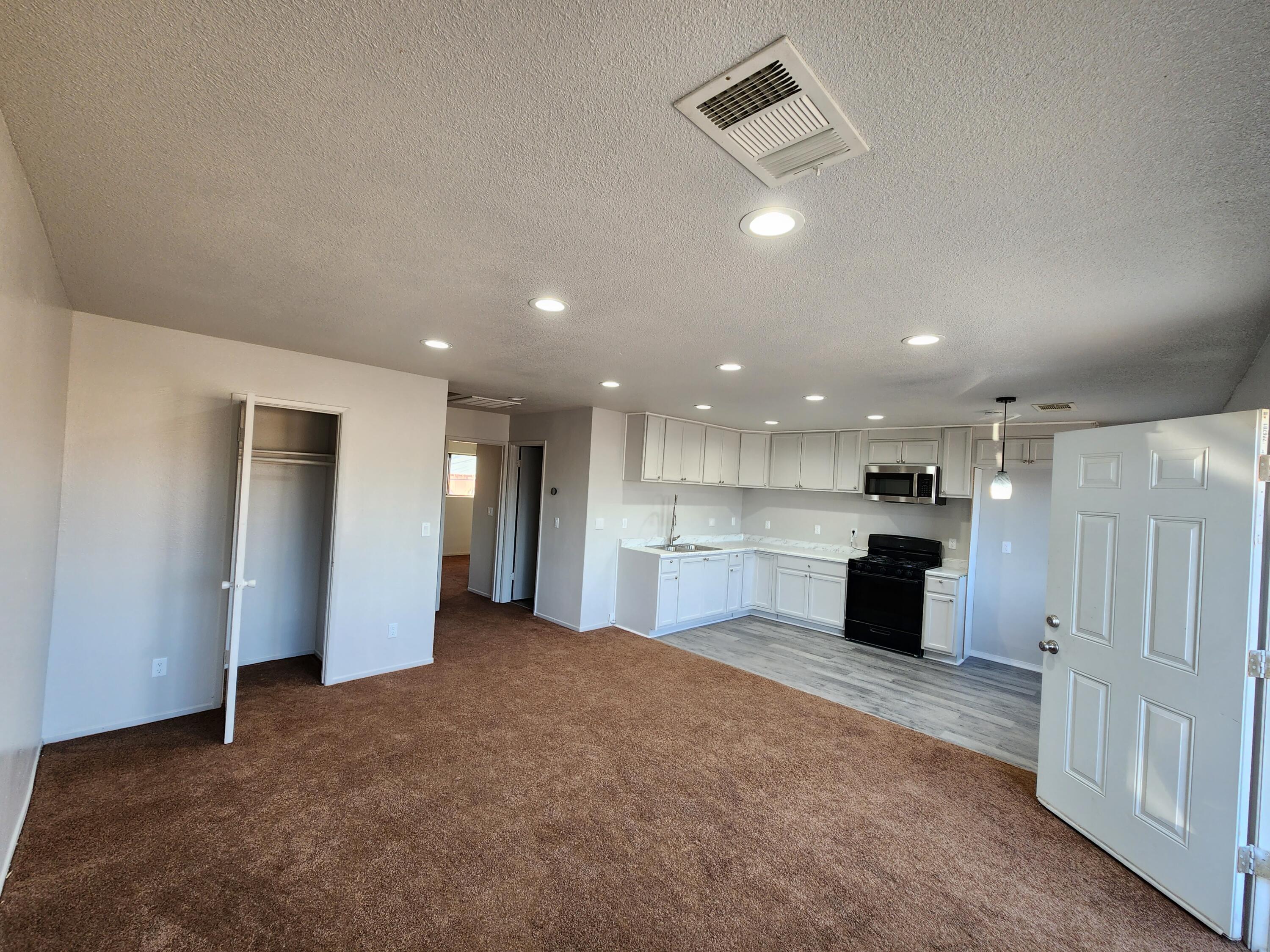 a view of a kitchen with a sink and a refrigerator