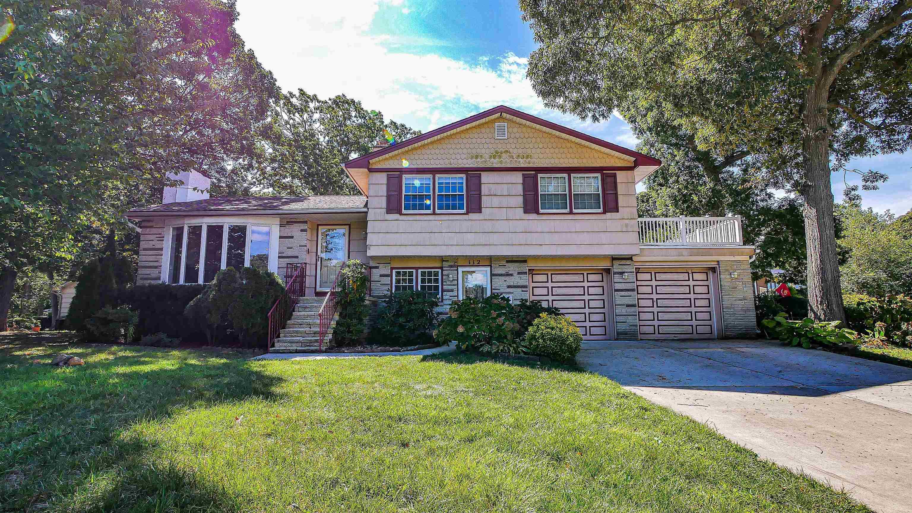 a front view of a house with a garden and yard