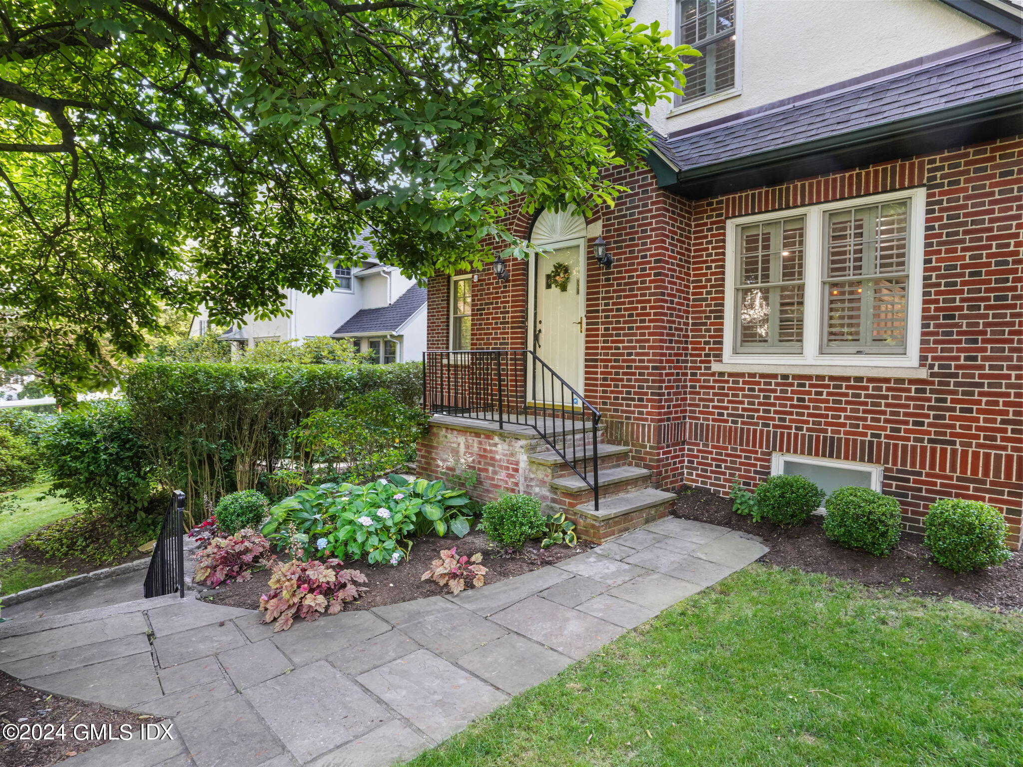 a front view of a house with a garden