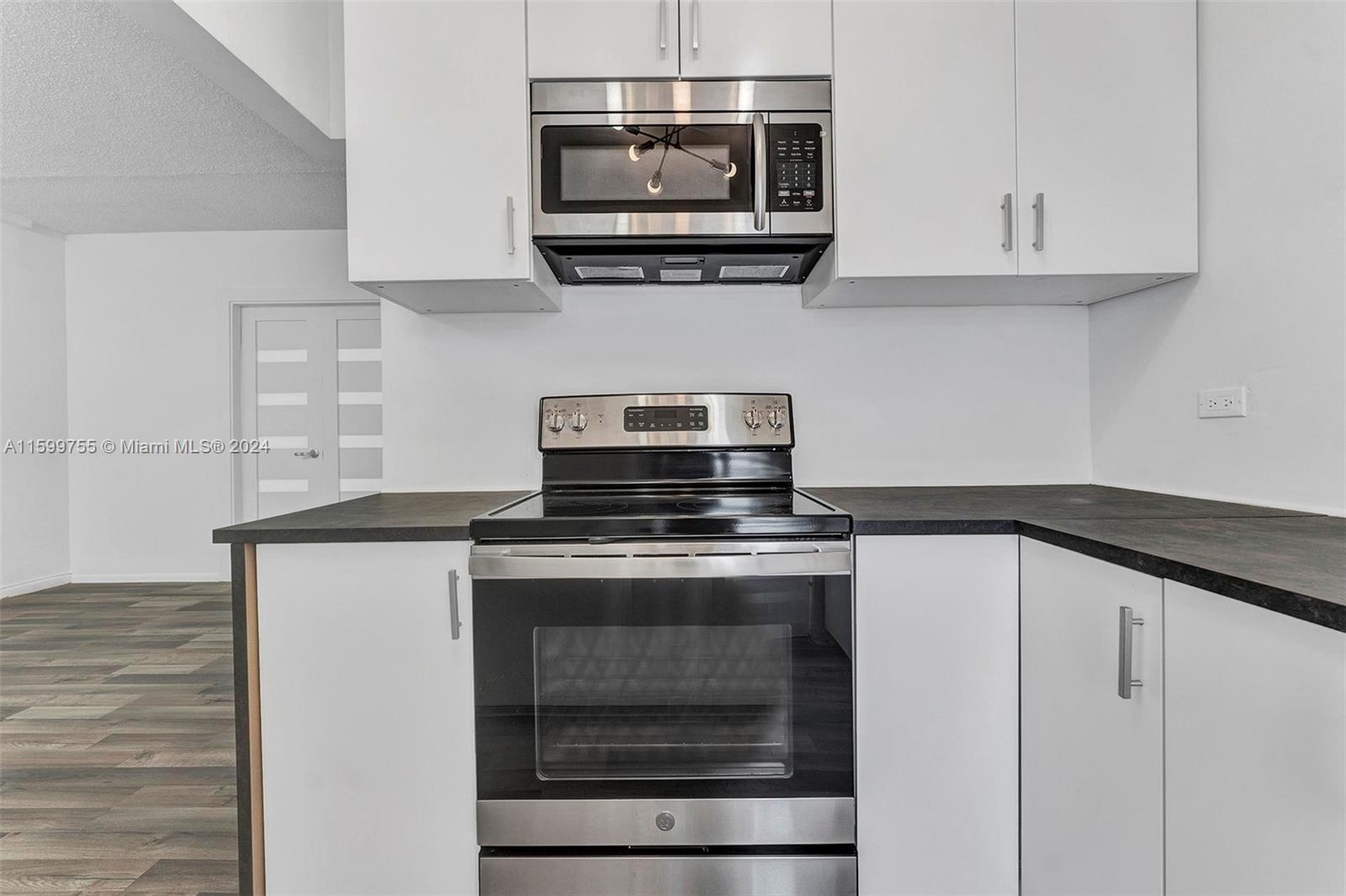 a kitchen with stainless steel appliances granite countertop a stove and a microwave