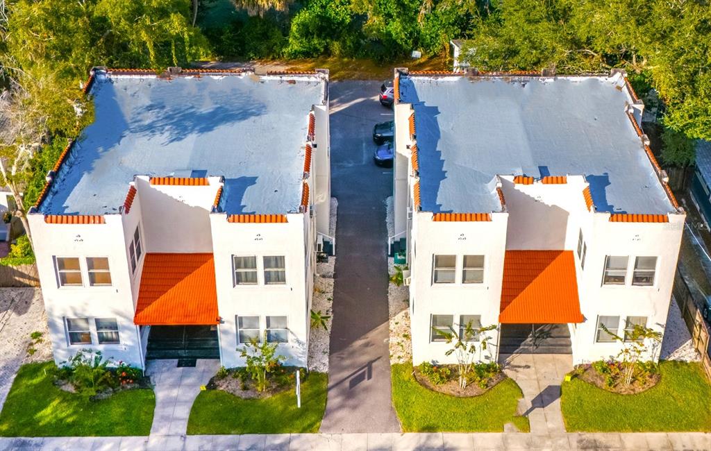 an aerial view of residential houses with outdoor space and parking