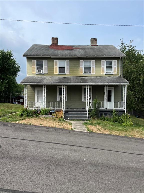 a front view of a house with a garden and plants