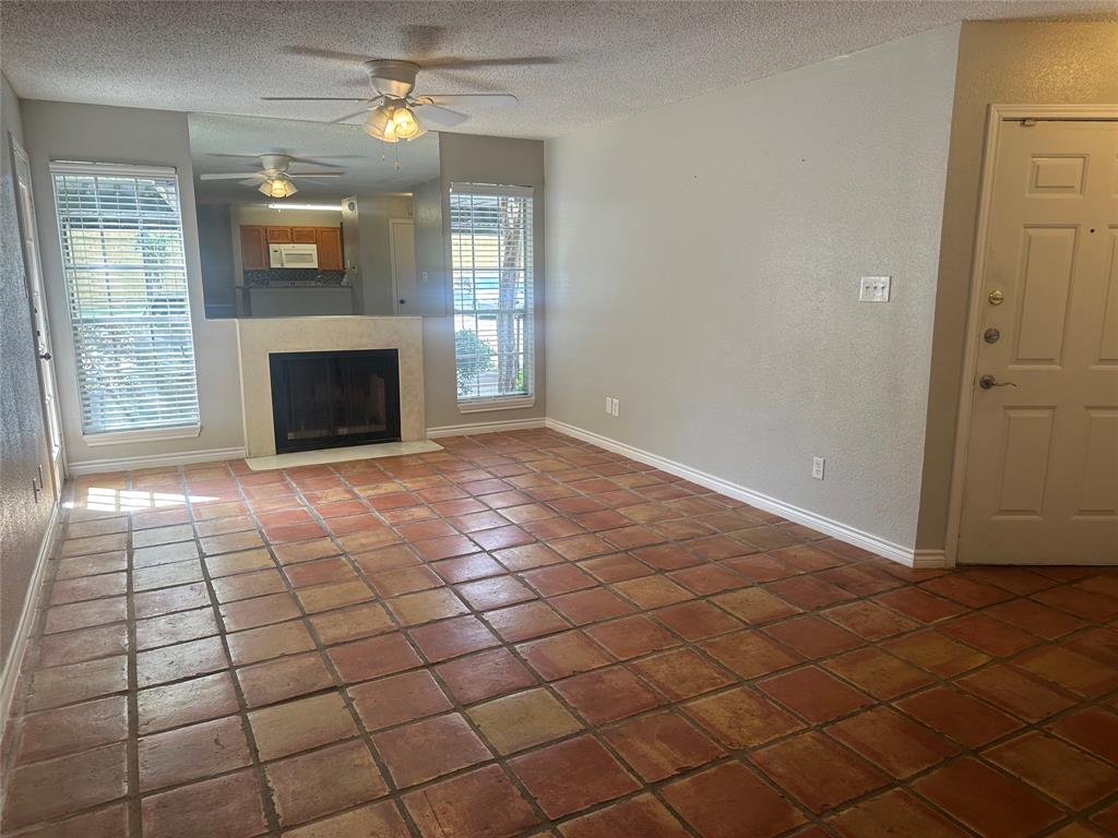 an empty room with windows and fireplace