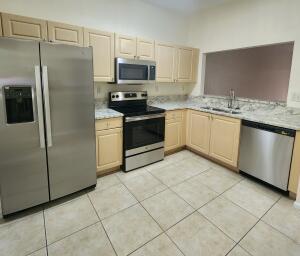 a kitchen with stainless steel appliances granite countertop a refrigerator sink and microwave