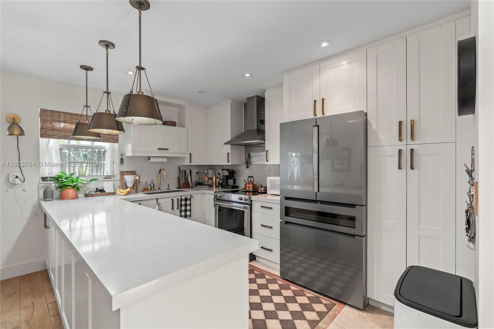 a kitchen with kitchen island a counter top space a sink stainless steel appliances and cabinets