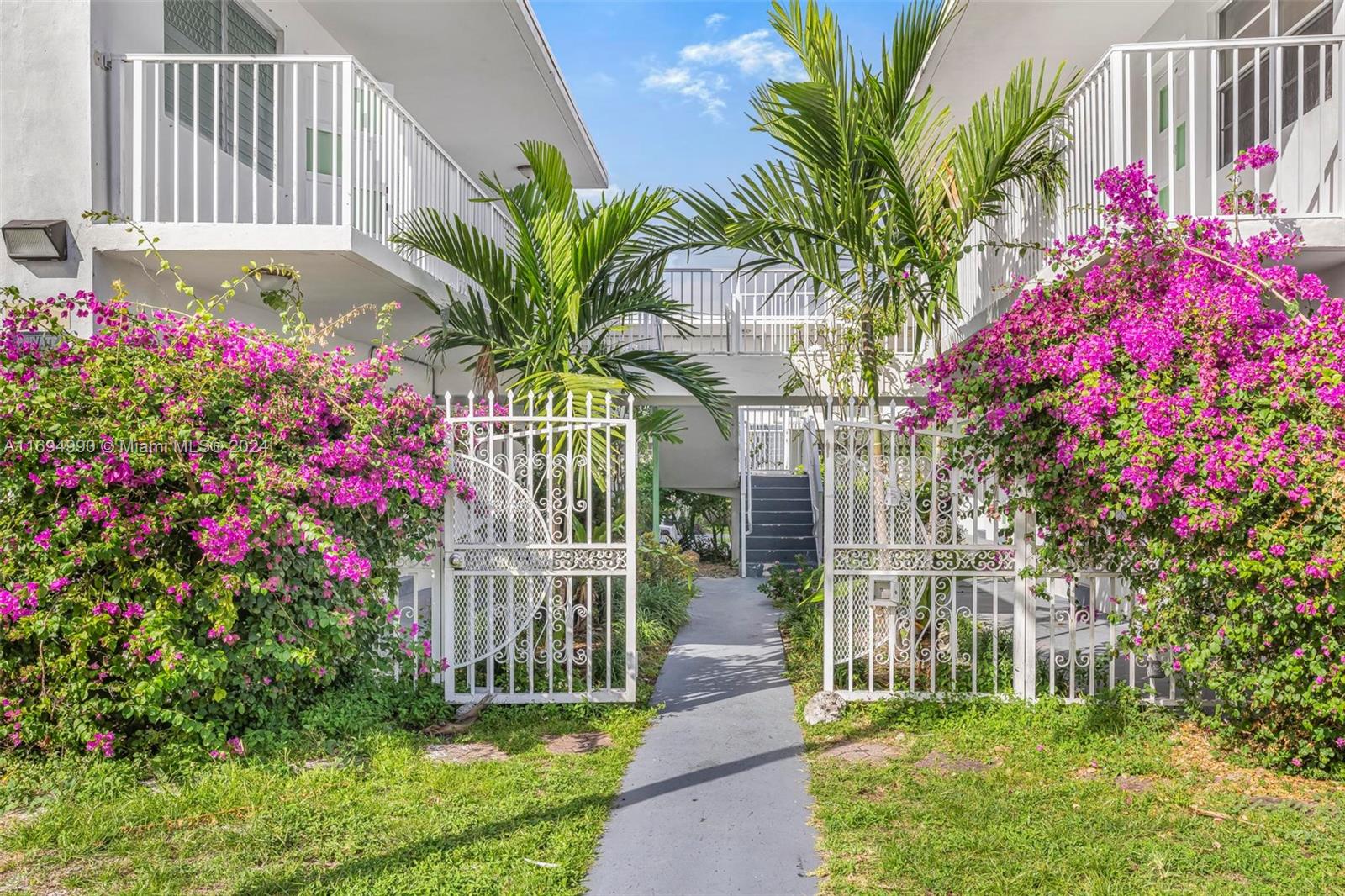 a front view of a house with a big yard and flower plants