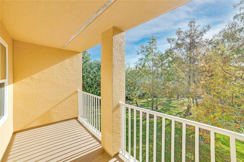 a view of a balcony with wooden floor and iron fence