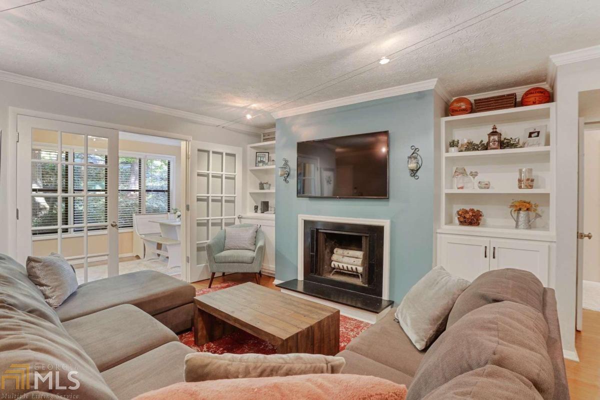 a living room with furniture a flat screen tv and a fireplace