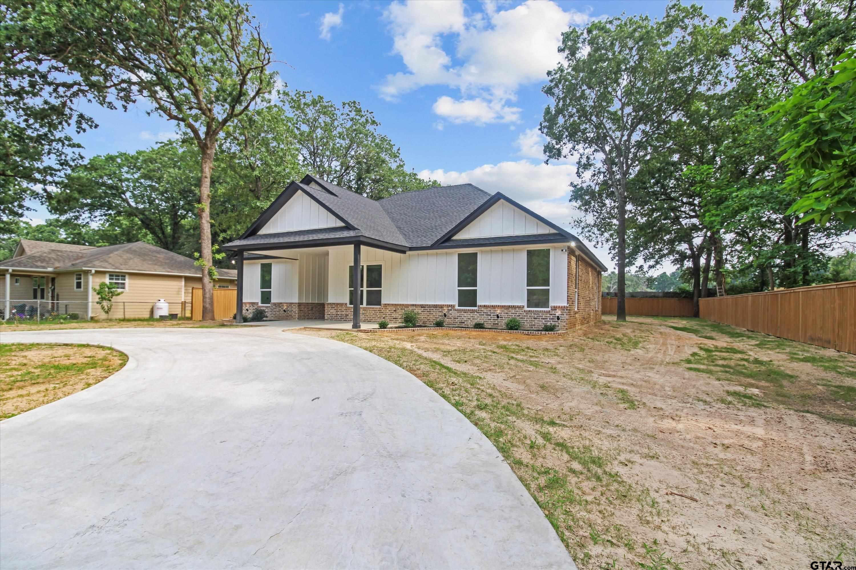 a front view of a house with yard and trees