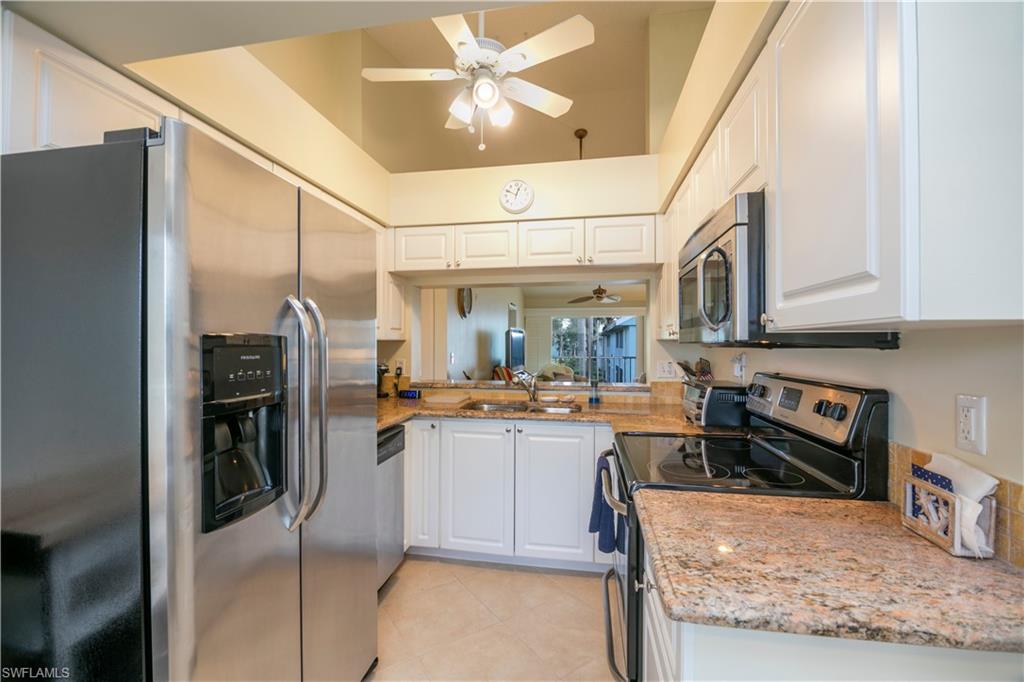 a kitchen with stainless steel appliances granite countertop a refrigerator a stove and a sink