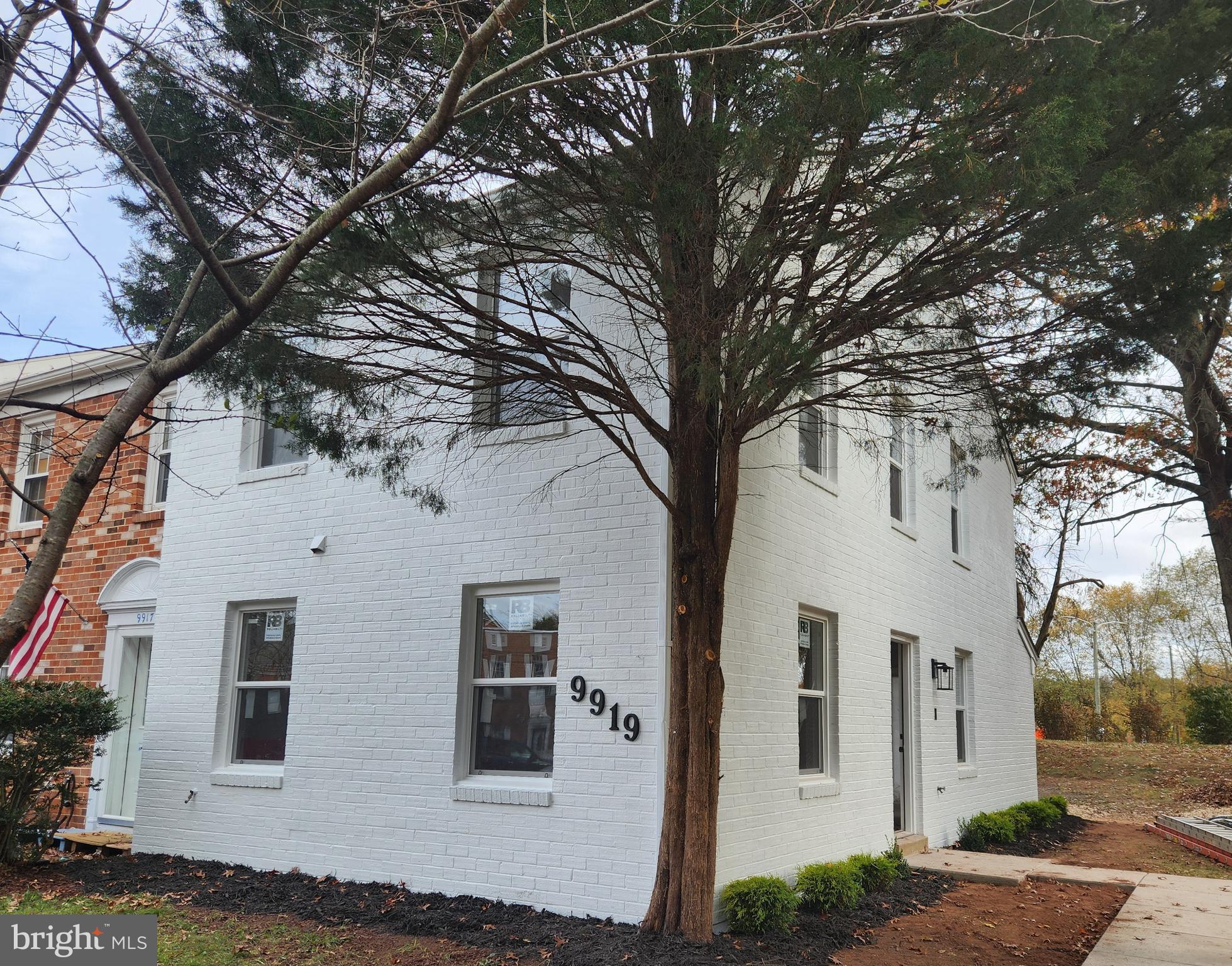 a white house that has a tree in front of it