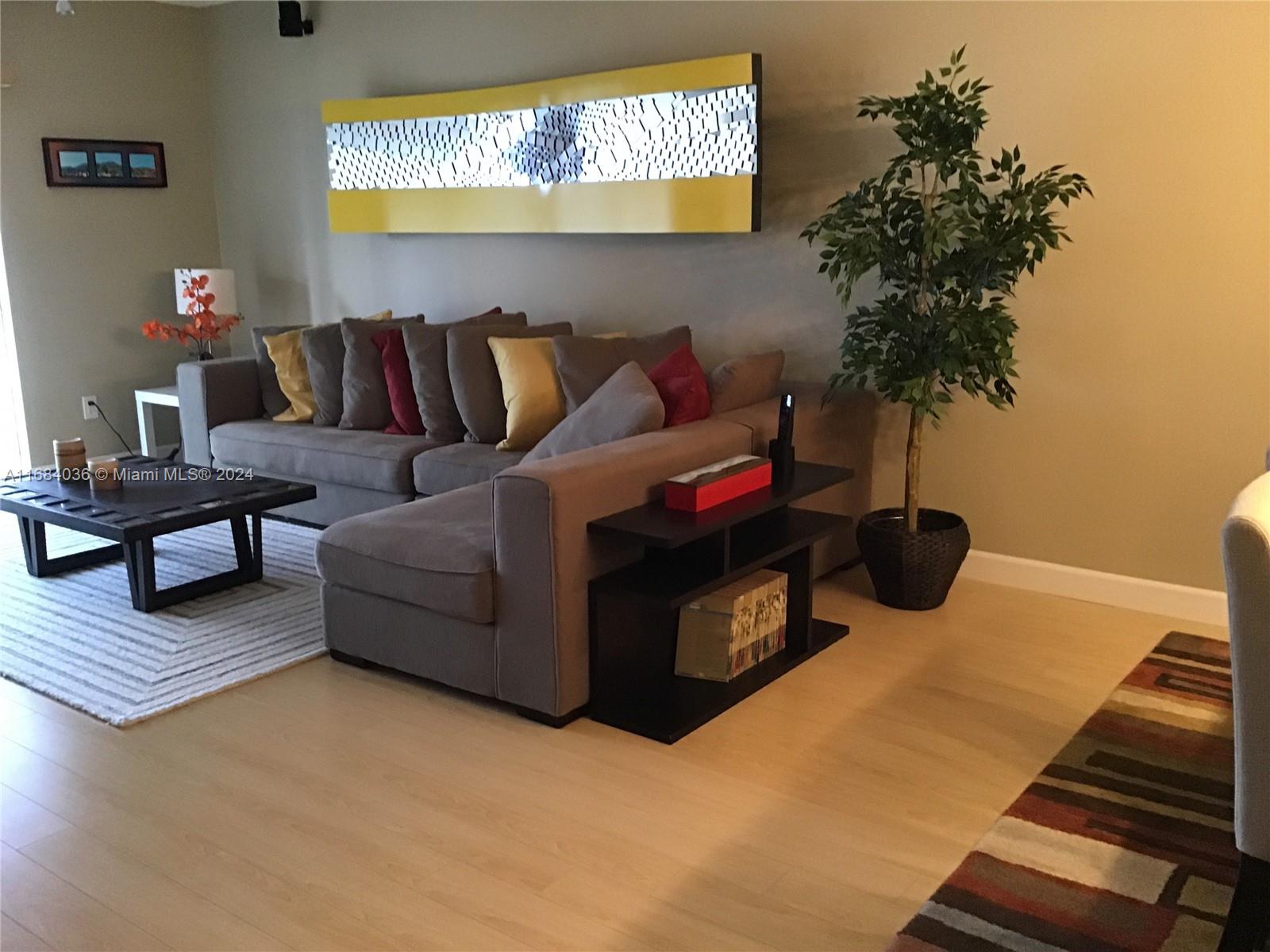 a living room with furniture and a potted plant