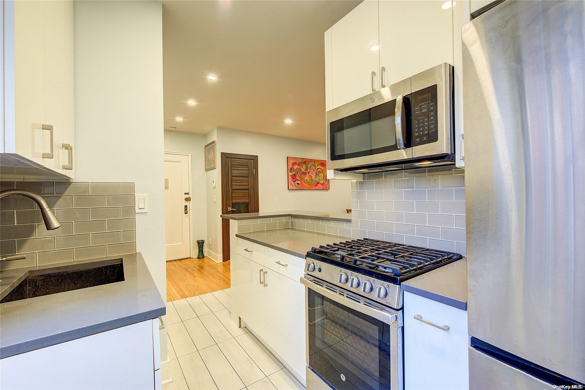 a kitchen with stainless steel appliances granite countertop a stove and a microwave