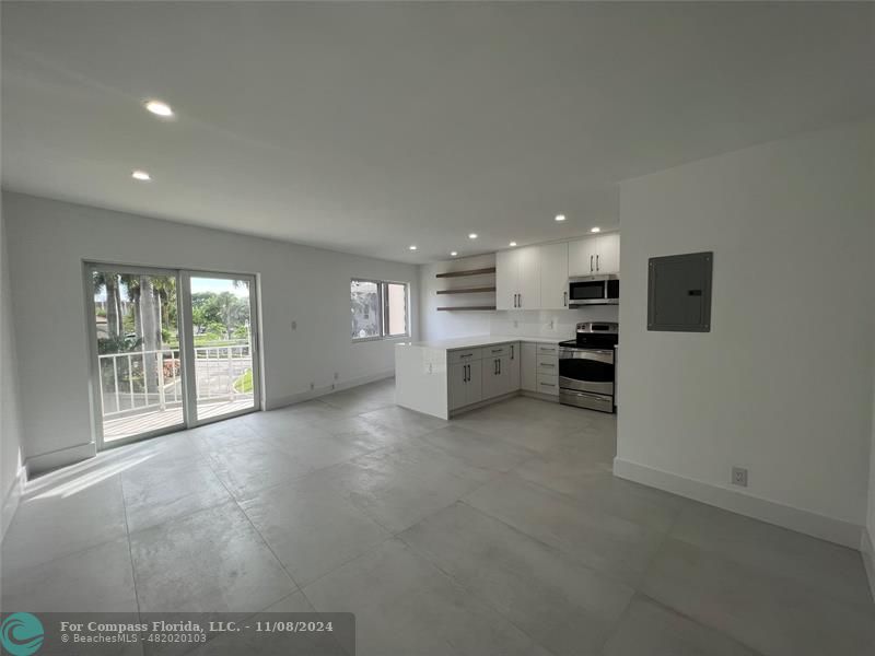 a view of an empty room with a kitchen