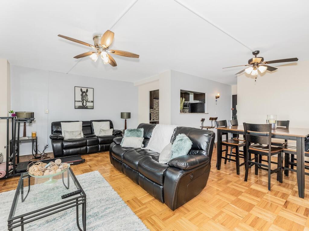 Living room with light parquet flooring and ceiling fan