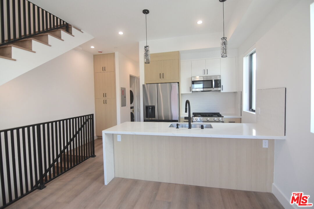 a large kitchen with kitchen island a sink stainless steel appliances and cabinets