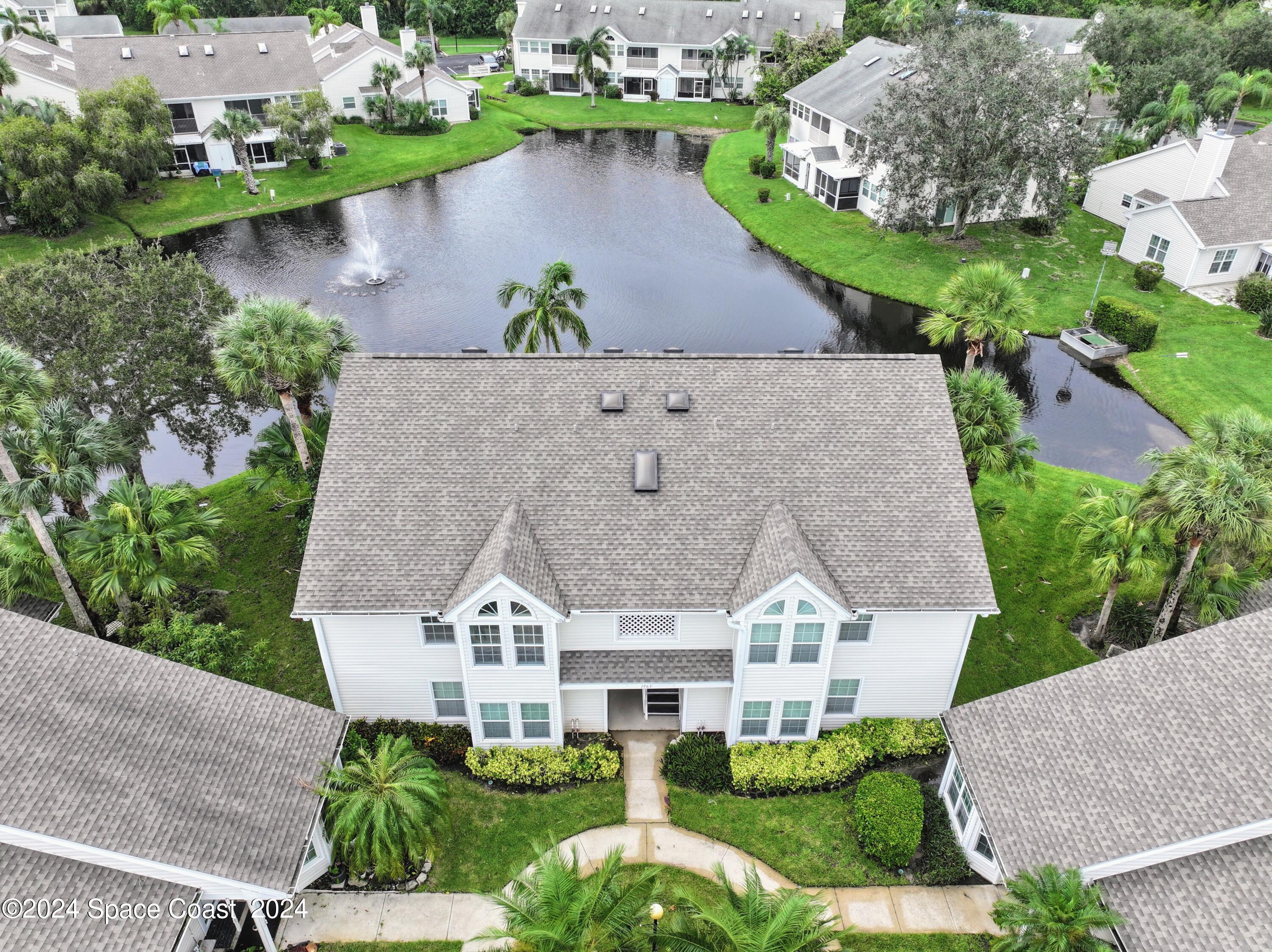 an aerial view of a house with a garden and lake view