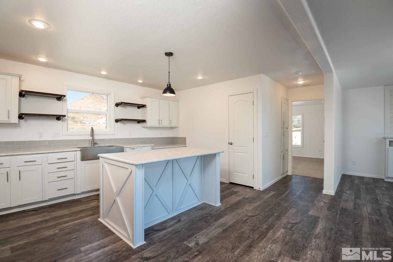 a large kitchen with a lot of counter space and wooden floor