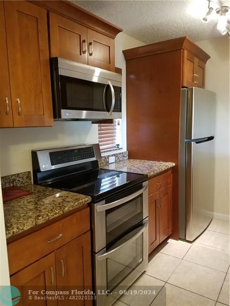 a kitchen with granite countertop a stove and a microwave