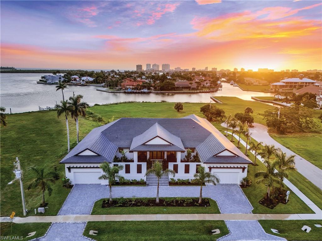 an aerial view of a house with swimming pool garden and lake view