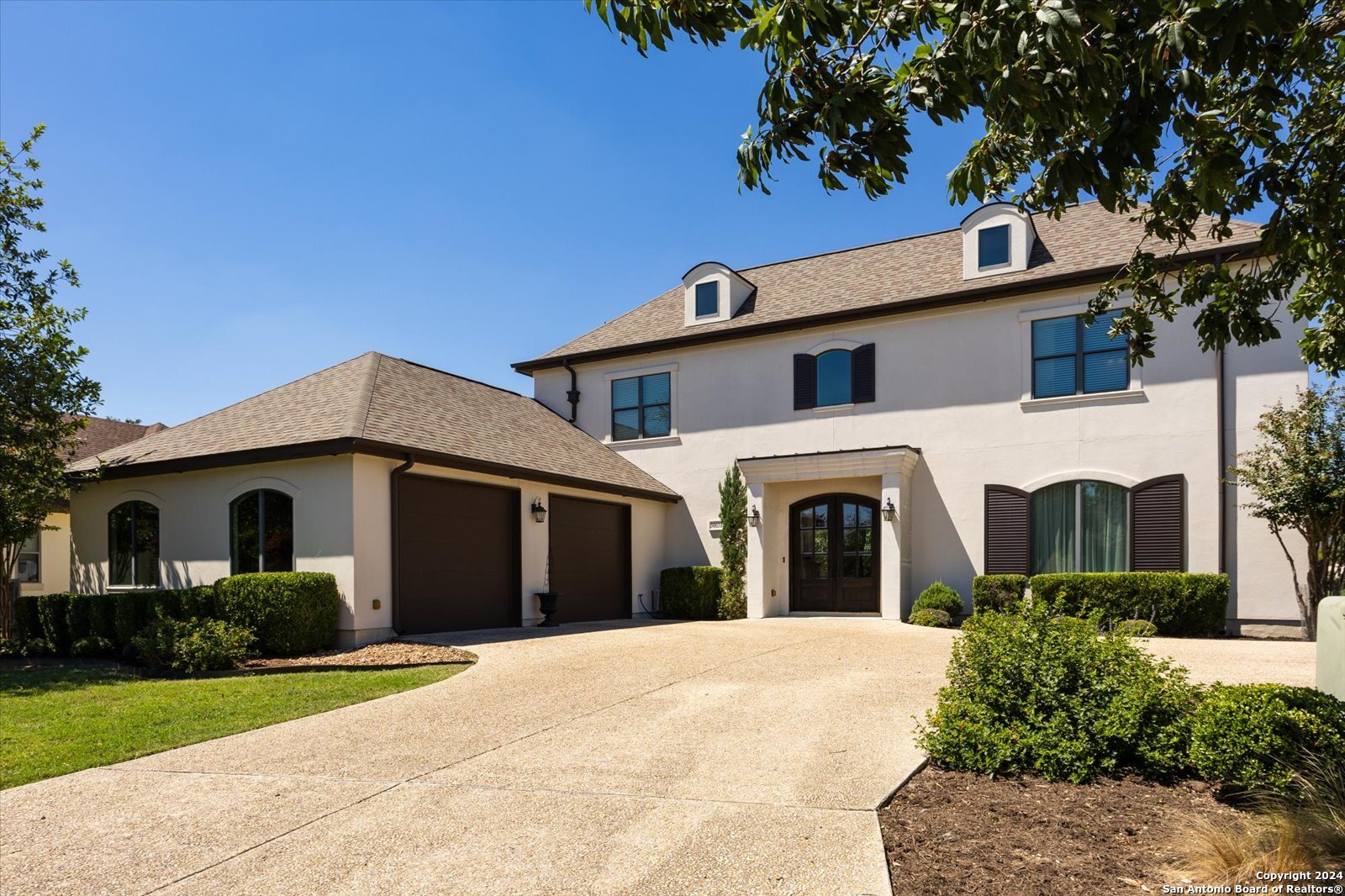 a front view of a house with a garden