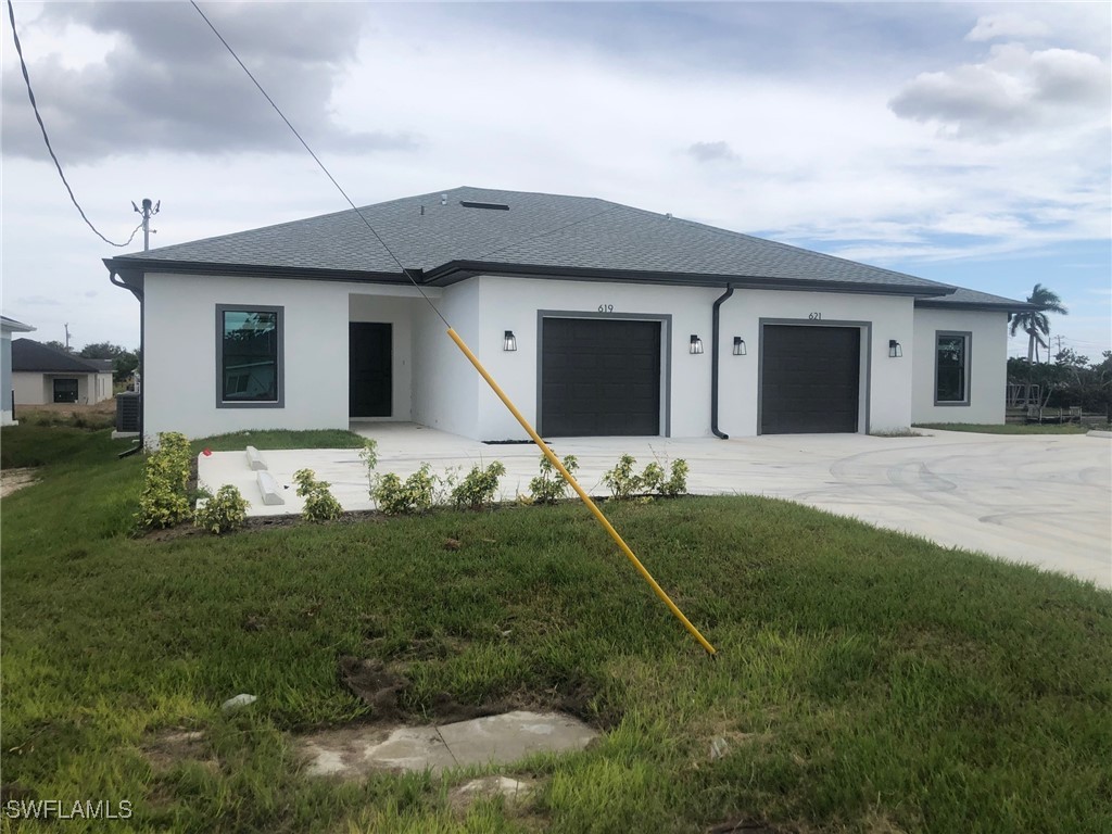 a front view of house with yard and garage