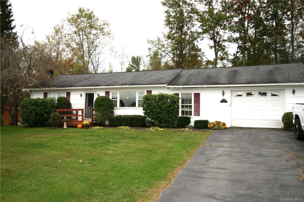 a view of a house with a yard and sitting area