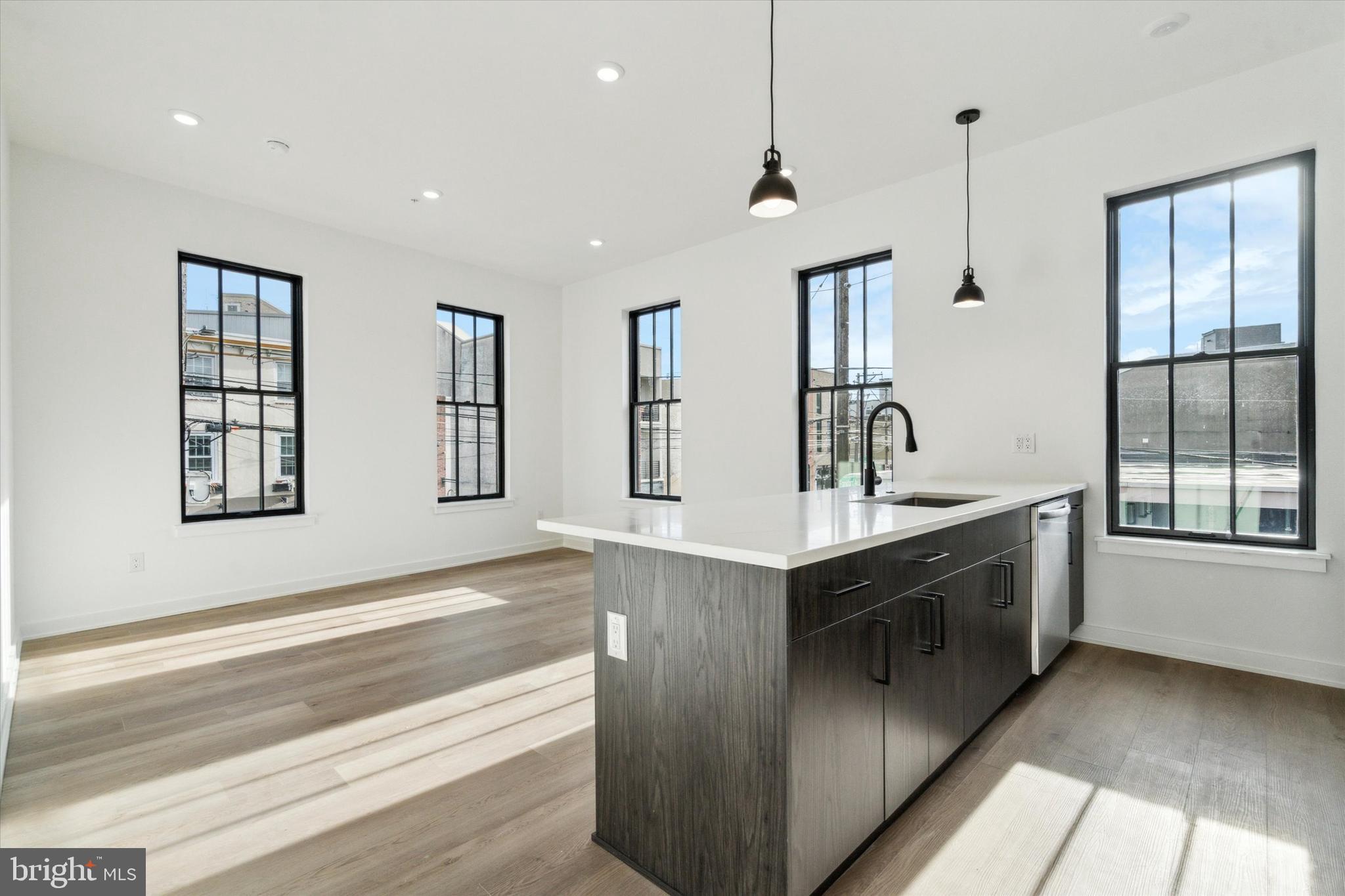 a kitchen with stainless steel appliances granite countertop a sink and dishwasher refrigerator with wooden floor