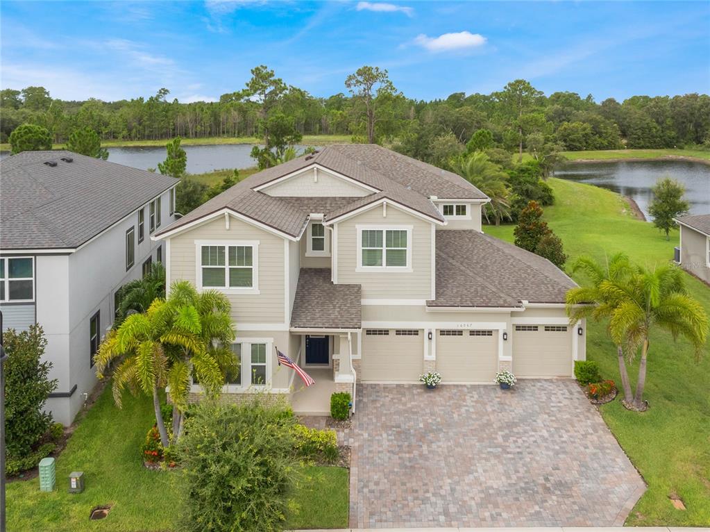 a aerial view of a house with a yard and lake view