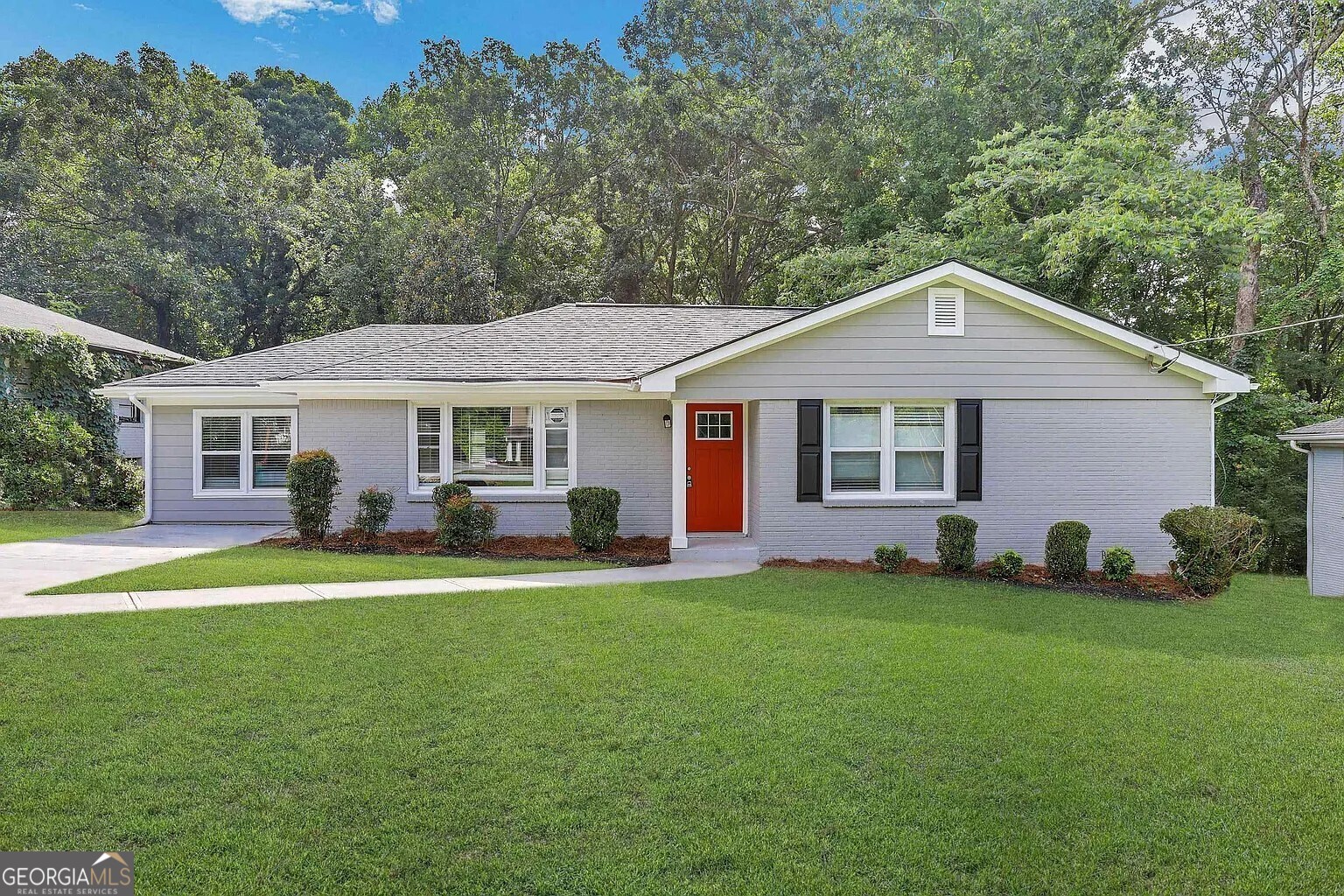 a front view of a house with a garden and trees